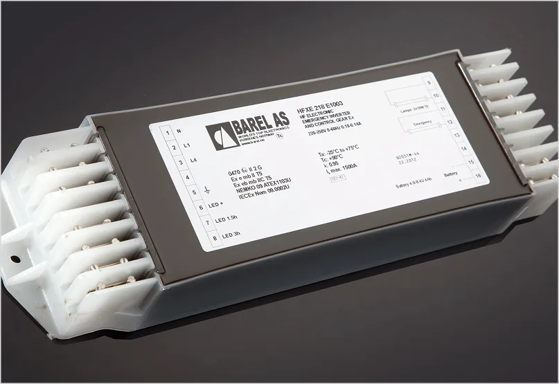 A BAREL AS HFXE 218 E1003 electronic emergency inverter and control gear module, shown at an angle on a dark surface.