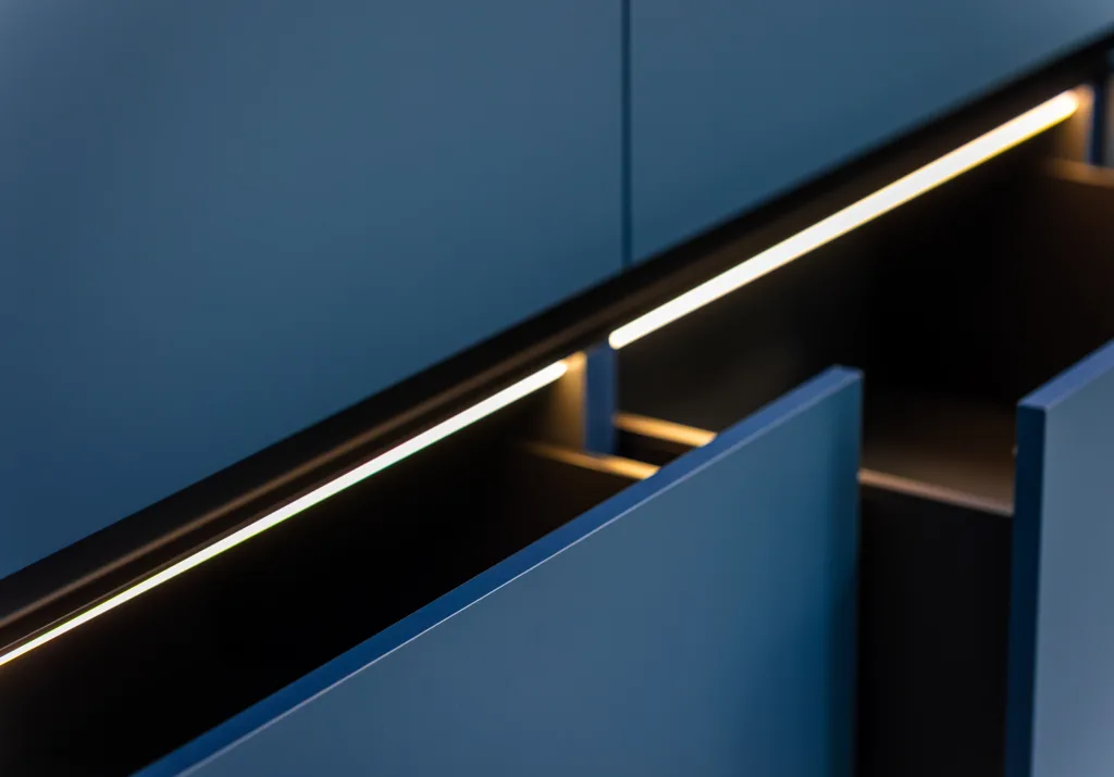 Modern blue cabinets with integrated LED strip lighting illuminating the interior.