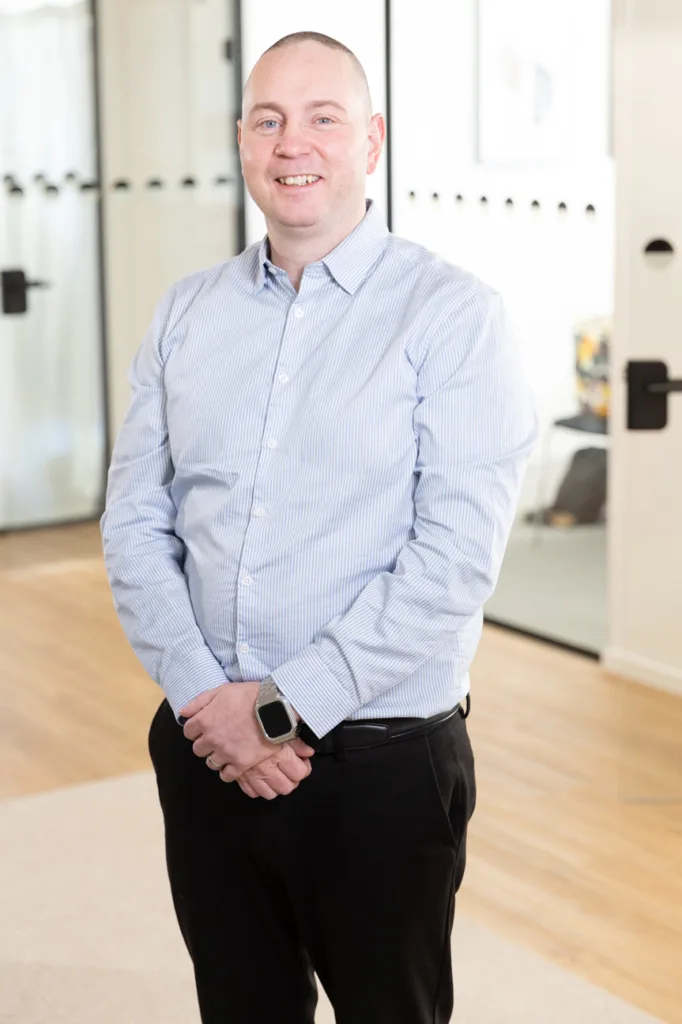 Portrait of a team member, photographed in a professional office environment.