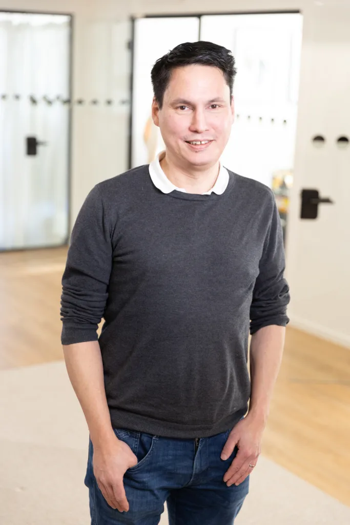 Portrait of a team member, photographed in a professional office environment.