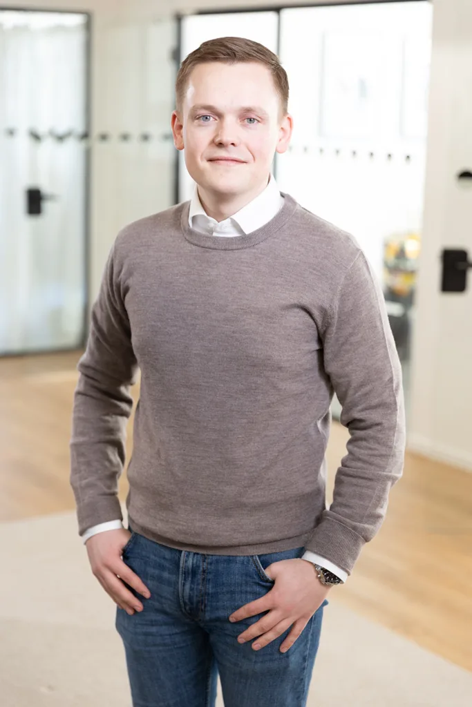 Portrait of a team member, photographed in a professional office environment.